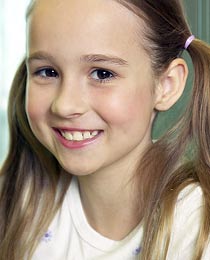 photo of a young girl smiling with healthy gums and teeth